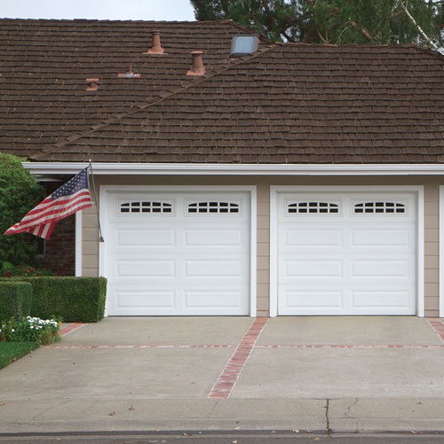 Beige three ar garage with white doors and brick and red brick d